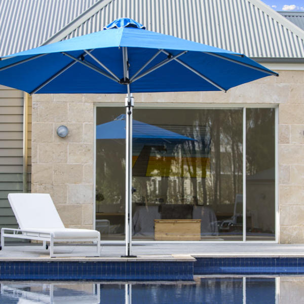 Large blue umbrella giving shade to a backyard pool in Torquay.