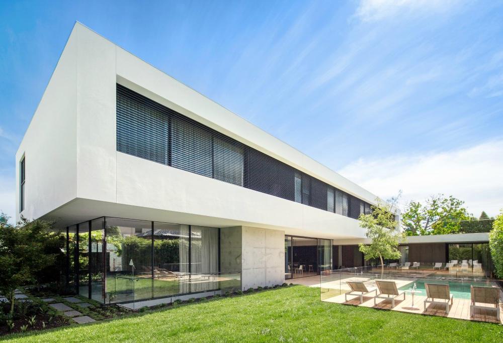 External venetian blinds on modern Geelong home with pool and green grass in foreground.