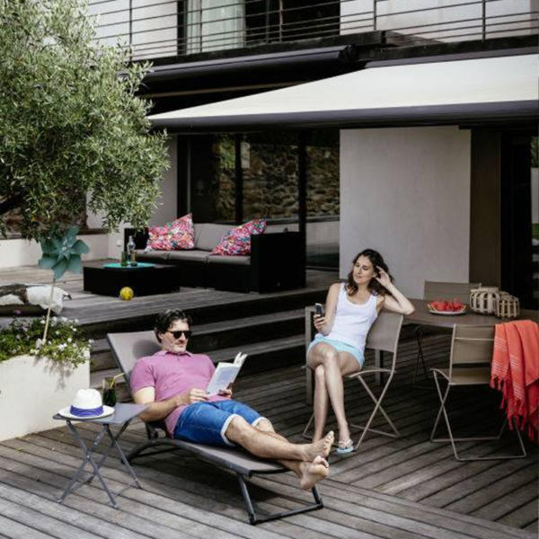 Couple lounging underneath exterior motorised blinds in Geelong.