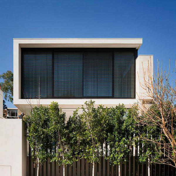 External venetian blinds on modern Geelong home with trees and blue sky.