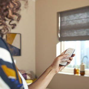 Woman using remote control for interior motorised blinds in Geelong.