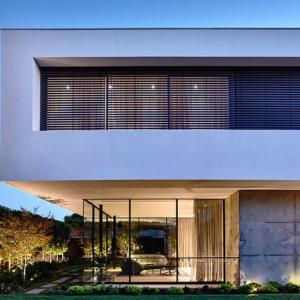 External venetian blinds on modern Geelong home at night.