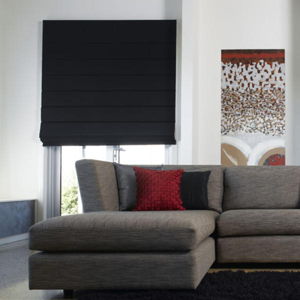 Black roman blinds on window in Geelong home in front of modern couch.