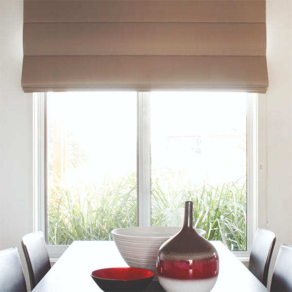 Dining room in home in Torquay with roman blinds on window.