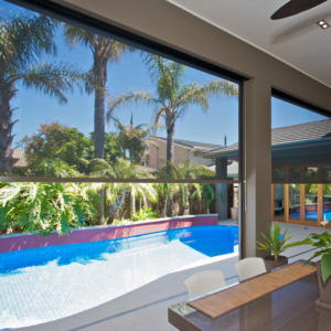 Awning on Torquay home overlooking pool and palm trees.